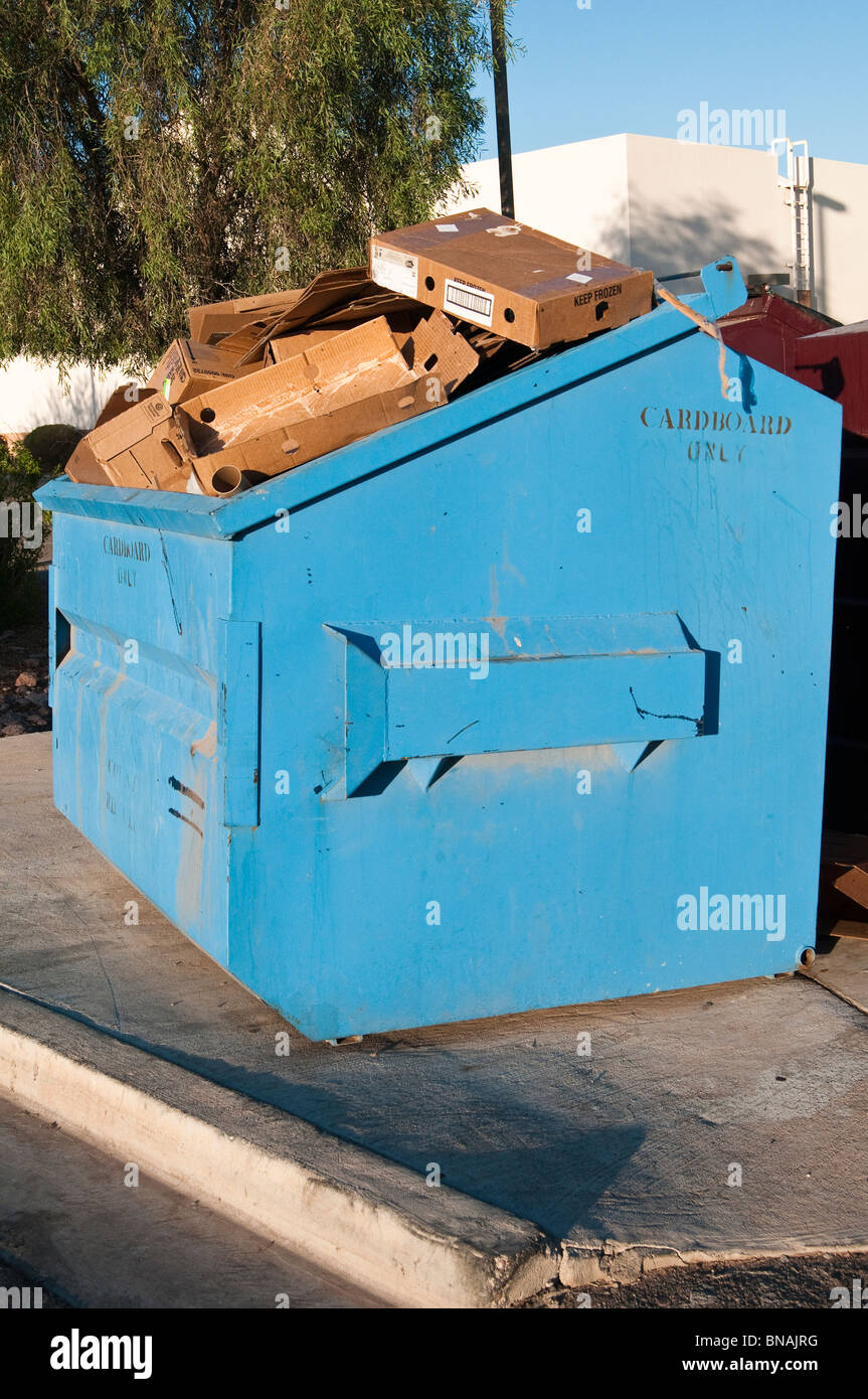 Ein blauer Müllcontainer ist voller Abfall Kartonmaterial. Stockfoto