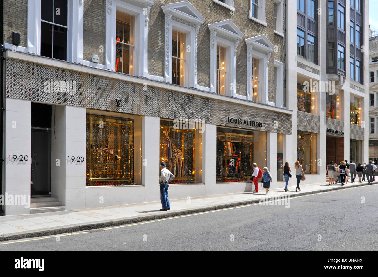 Louis Vuitton Französischer Luxusmodeladen vorne und dekorierte Fenster zeigen sonnigen Sommertag in New Bond Street Mayfair West End London England Stockfoto