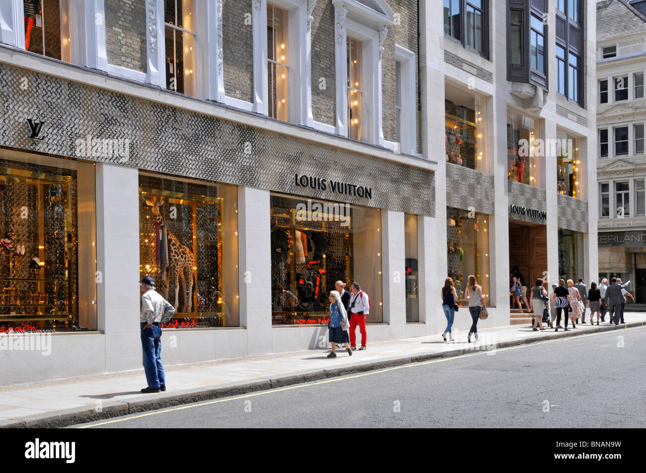 Louis Vuitton Französischer Luxusmodeladen vorne und dekorierte Fenster zeigen sonnigen Sommertag in New Bond Street Mayfair West End London England Stockfoto