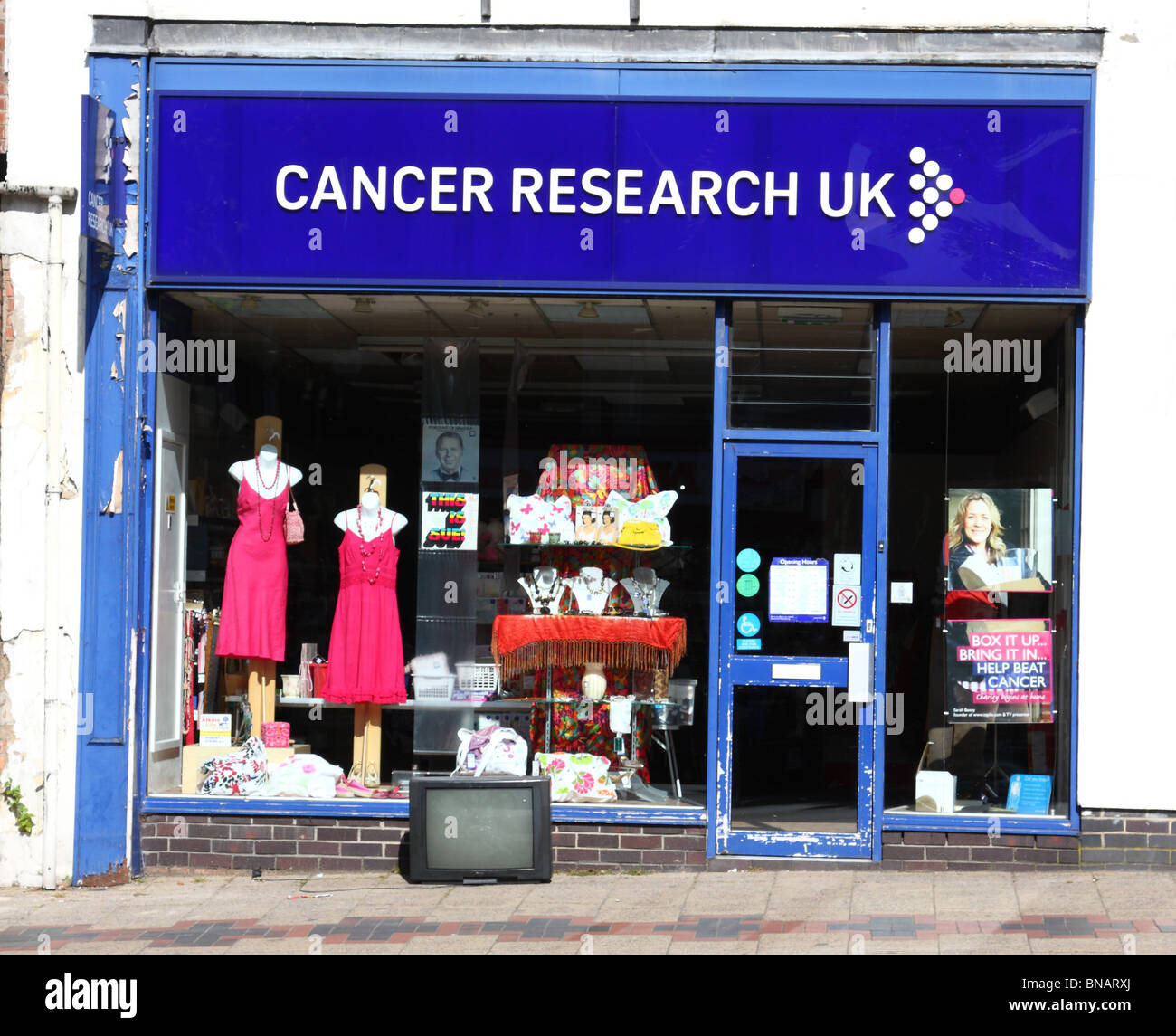 Ein alter Fernseher links außen eine Krebsforschung-Charity-Shop in einer Stadt, U.K. Stockfoto