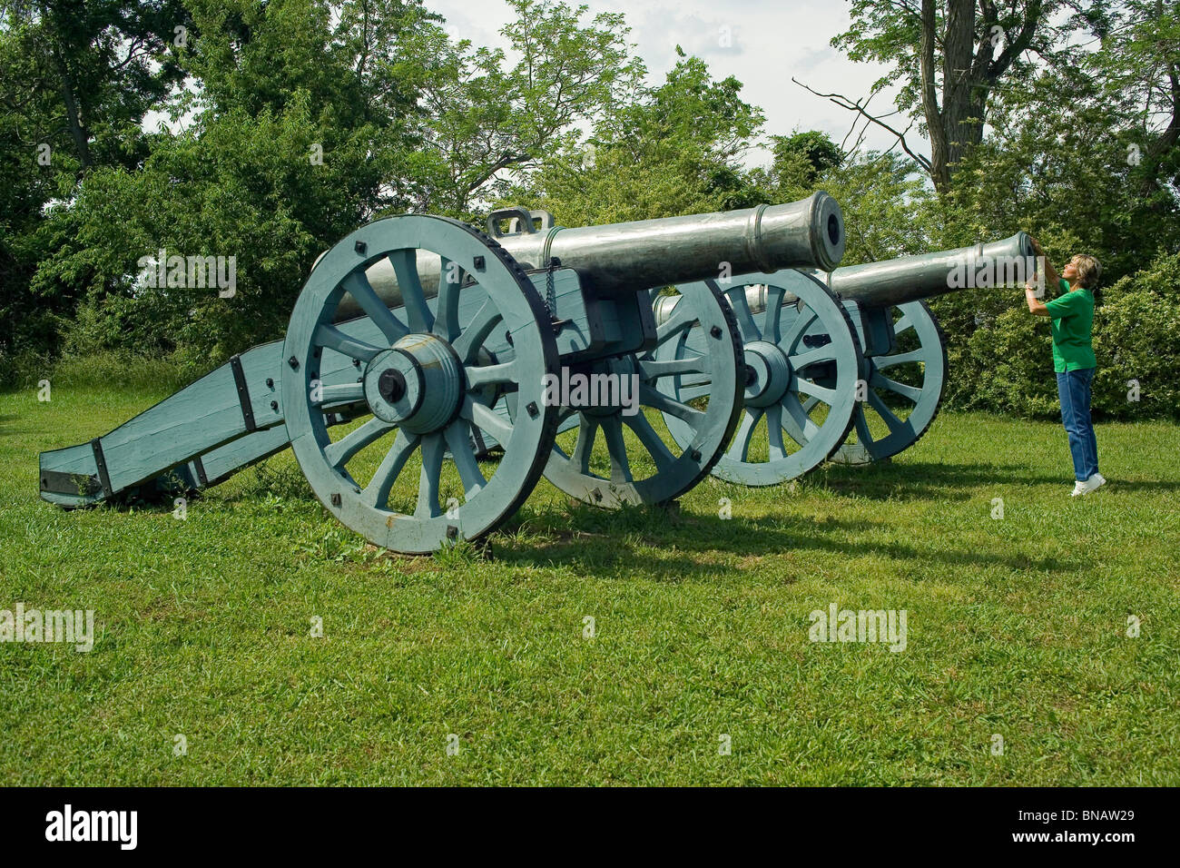 Ein Besucher inspiziert ein Unabhängigkeitskrieg Kanone in Colonial National Historical Park in Yorktown Battlefield in historischen Yorktown, Virginia, USA. Stockfoto