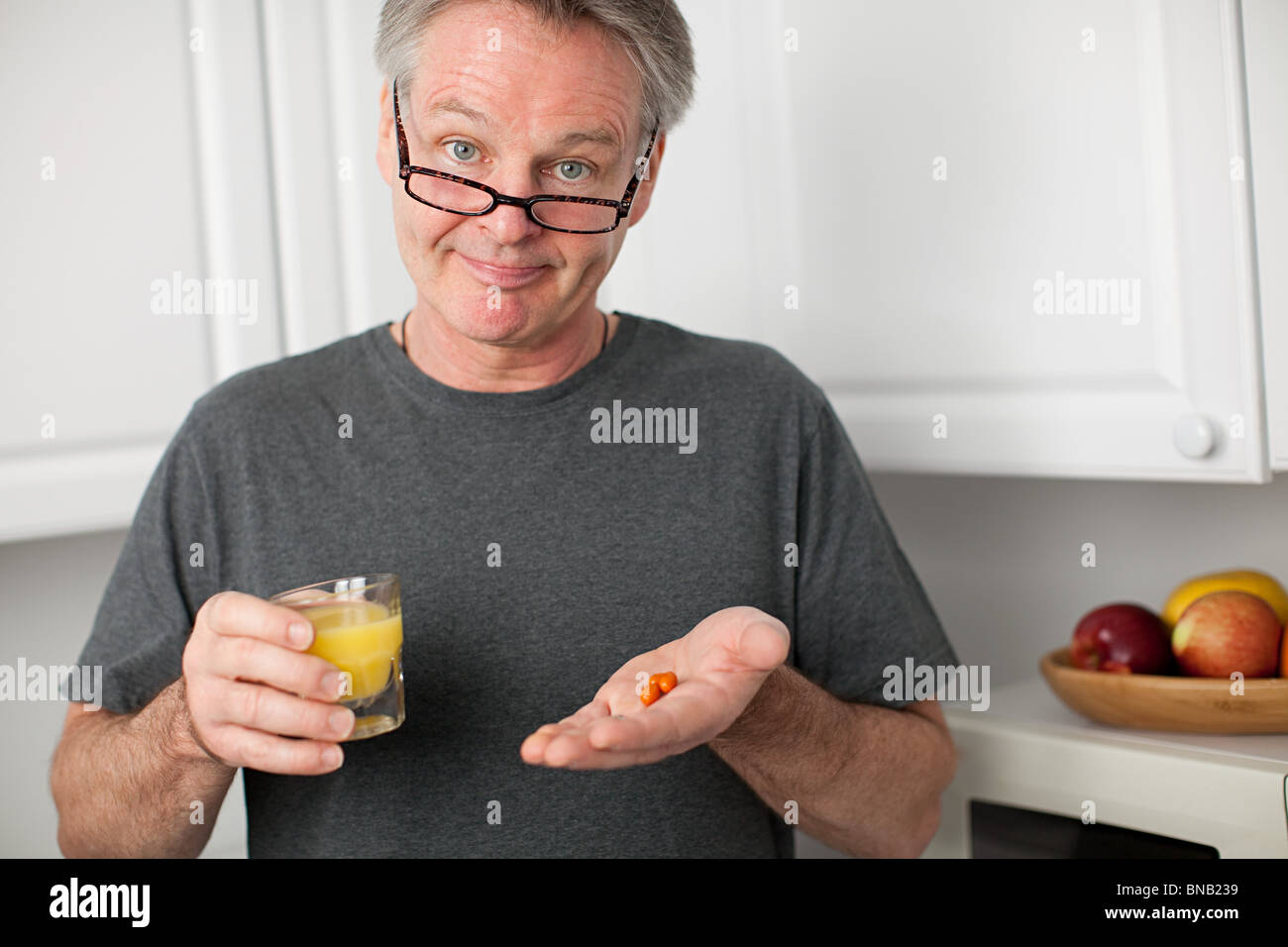 Mann mit Vitaminen und Orangensaft Stockfoto