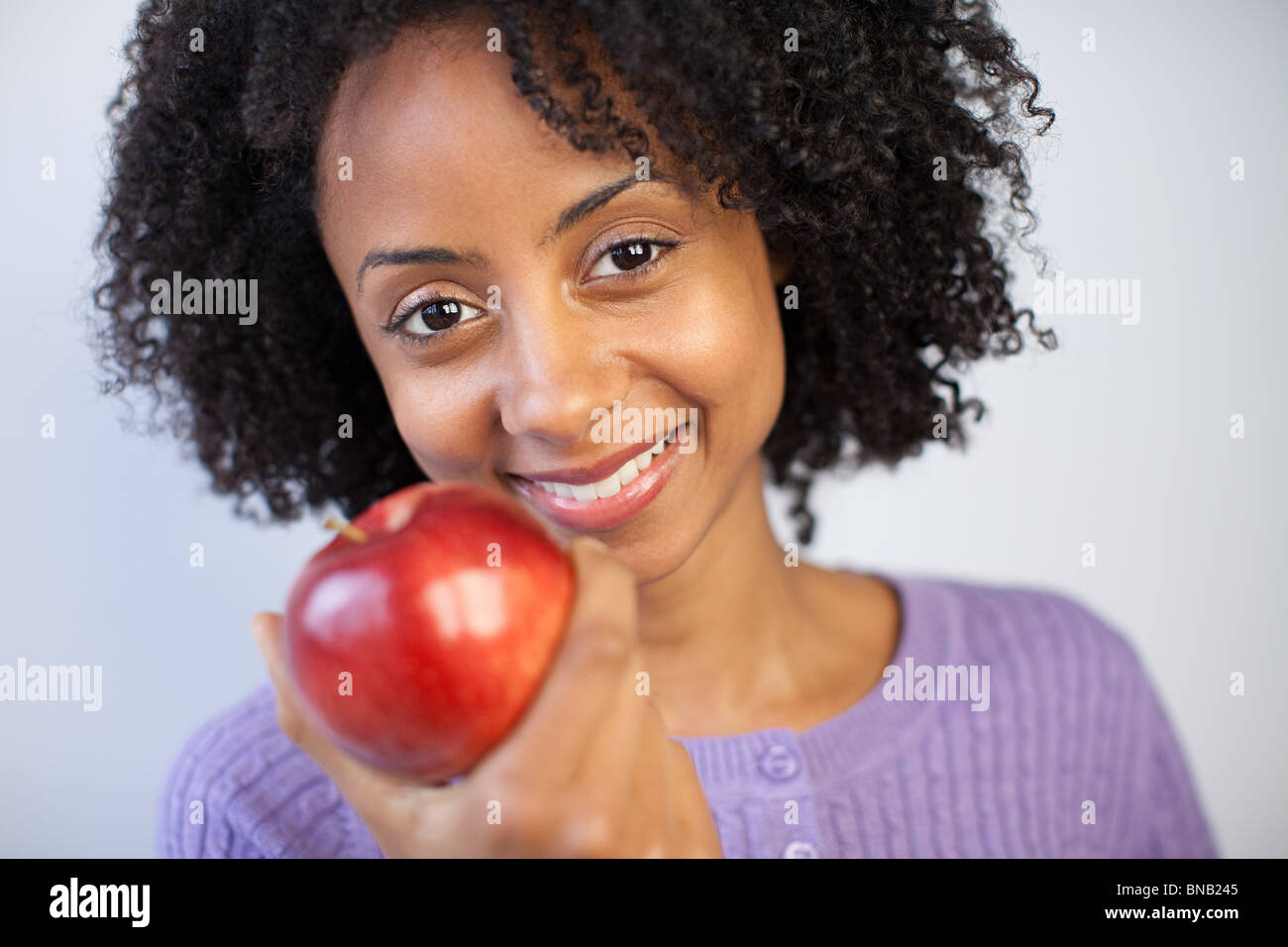 Frau hält einen Apfel Stockfoto