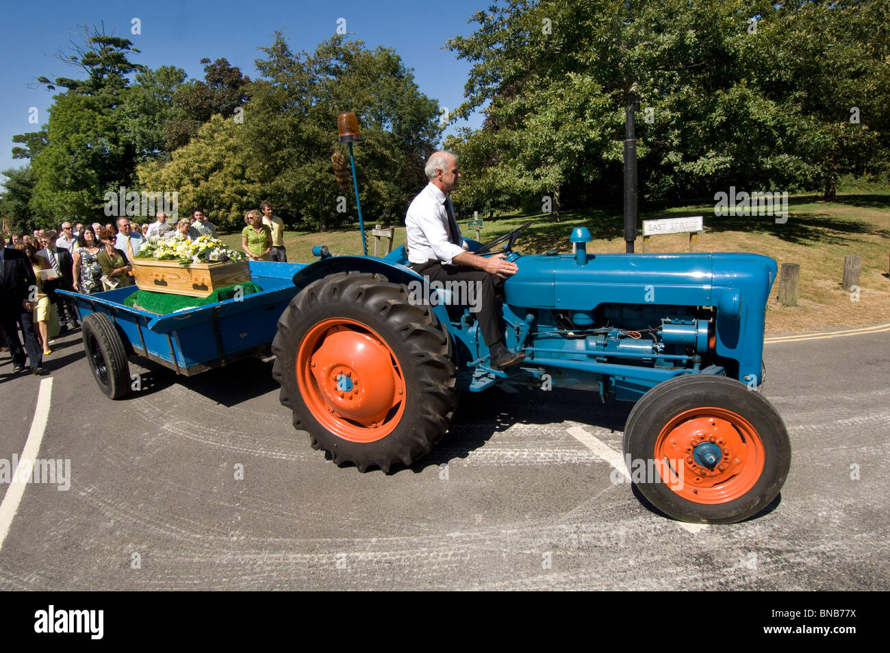 Ein Jahrgang 1960 Fordson Dexta Traktor zieht den Sarg in einem Dorf Beerdigung Porcession in Falmer, Sussex, England UK. Stockfoto