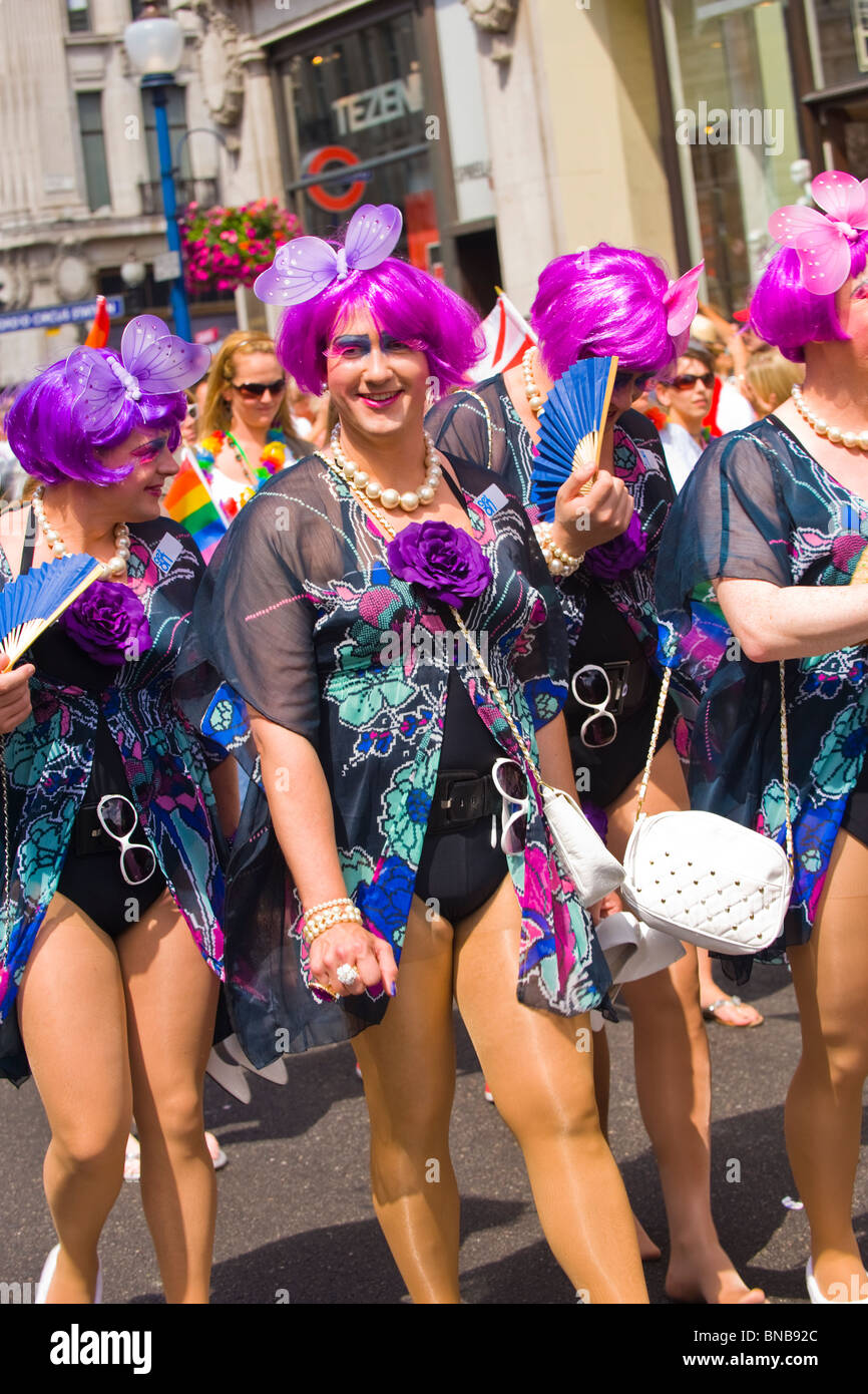 London Gay Pride, Männer in Drag, lila lila Perücken, Schmetterling, Hüte,  schwarze Trikots, Strumpfhose, weiße Taschen & Sonnenbrille Stockfotografie  - Alamy