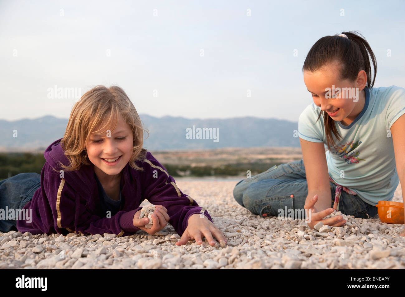 Sammeln von Steinen am Strand Mädchen Stockfoto