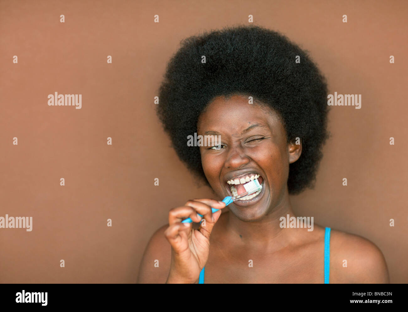 Junge schwarze Frau mit Afro Zähneputzen Stockfoto