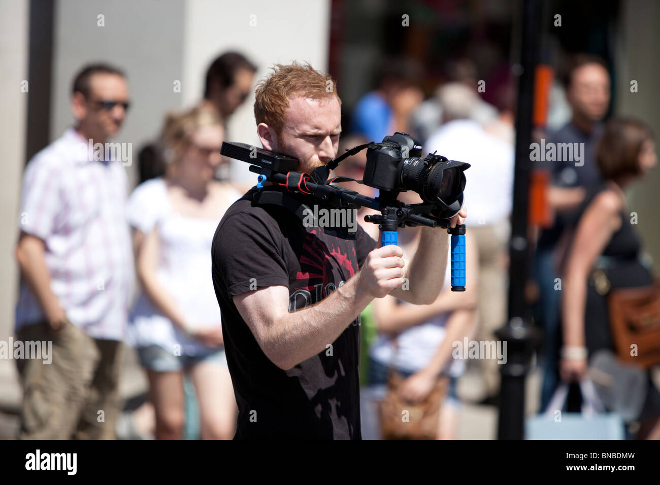 Aufnahmen von Videofilmen mit einer digitalen DLSR-Kamera, die auf einer Schulterstütze in London, England, Großbritannien montiert ist. Stockfoto
