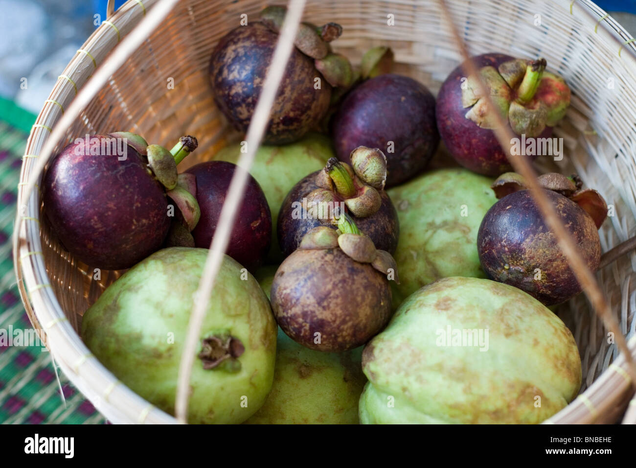 Mangostanfrüchte und andere tropische Früchte in einem Korb, Thailand Stockfoto