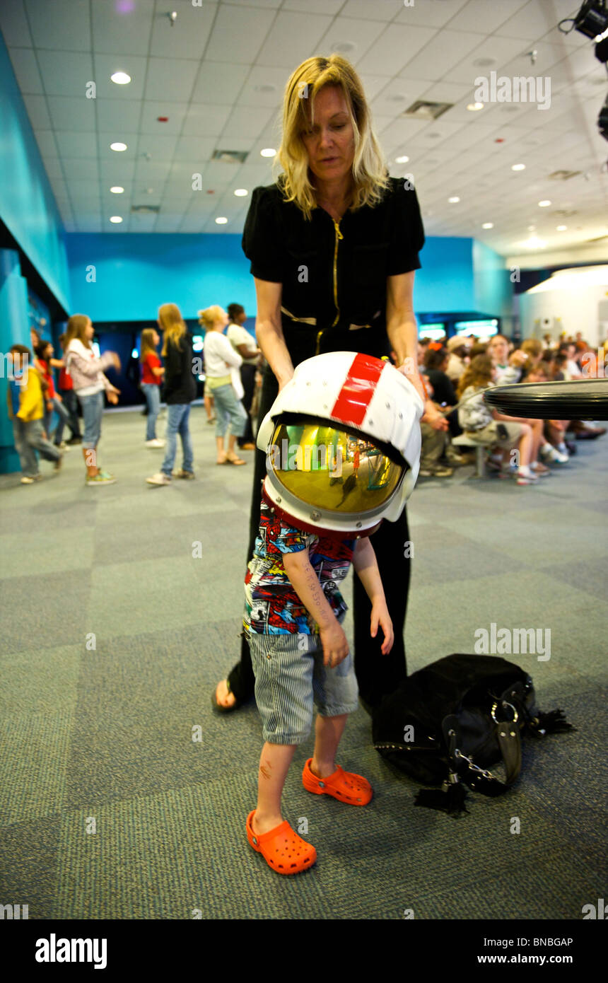Drei Jahre alter Junge versucht, auf eine schwere Astronauten Helm, Space Center Houston, Texas, USA Stockfoto
