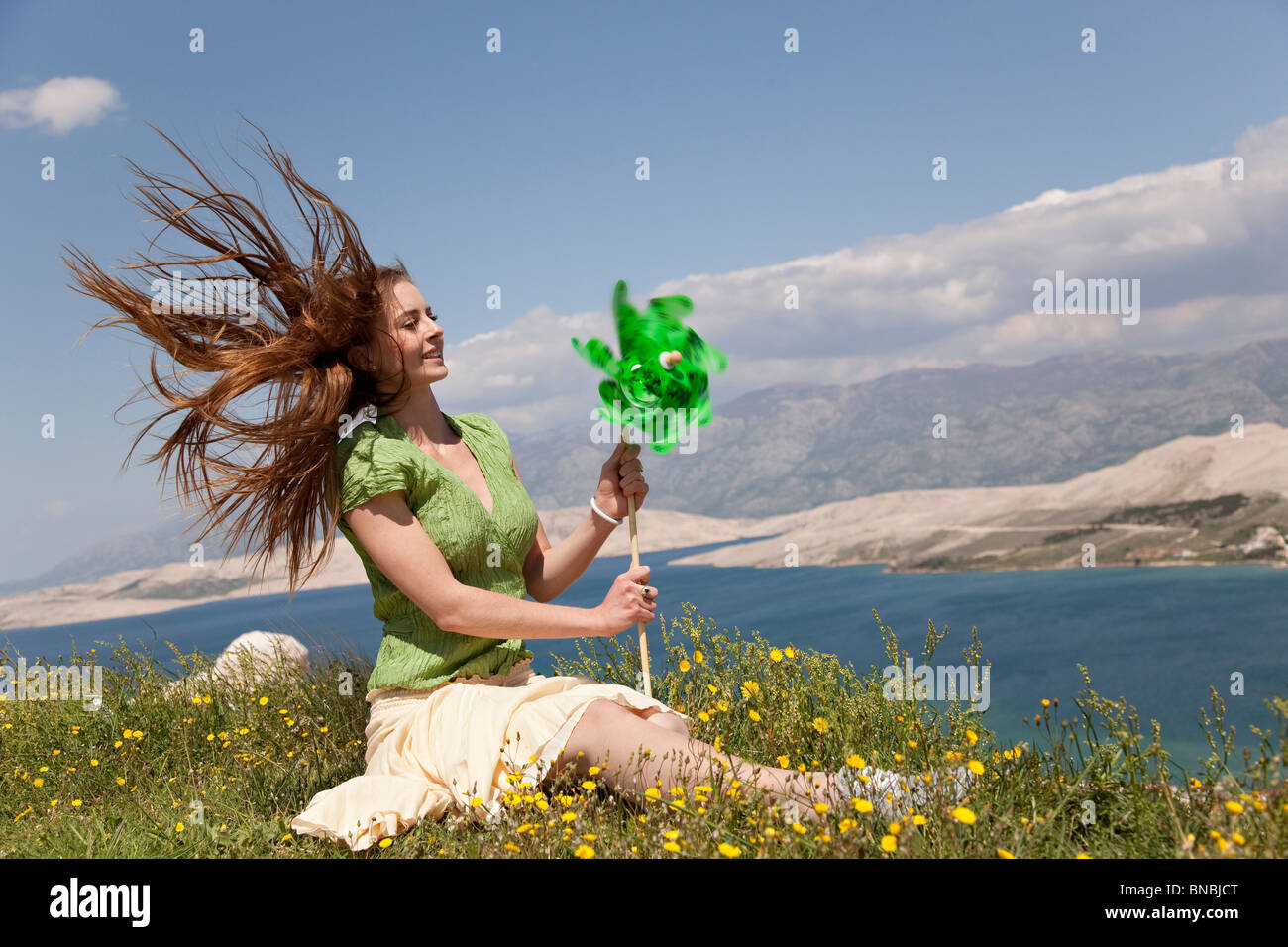 Frau mit Windrad auf dem Seeweg Stockfoto