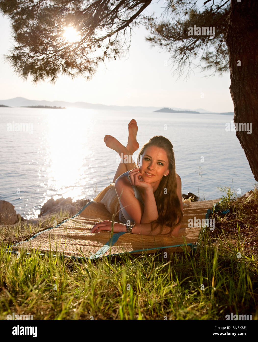 Frau liegend am Grasstrand Stockfoto