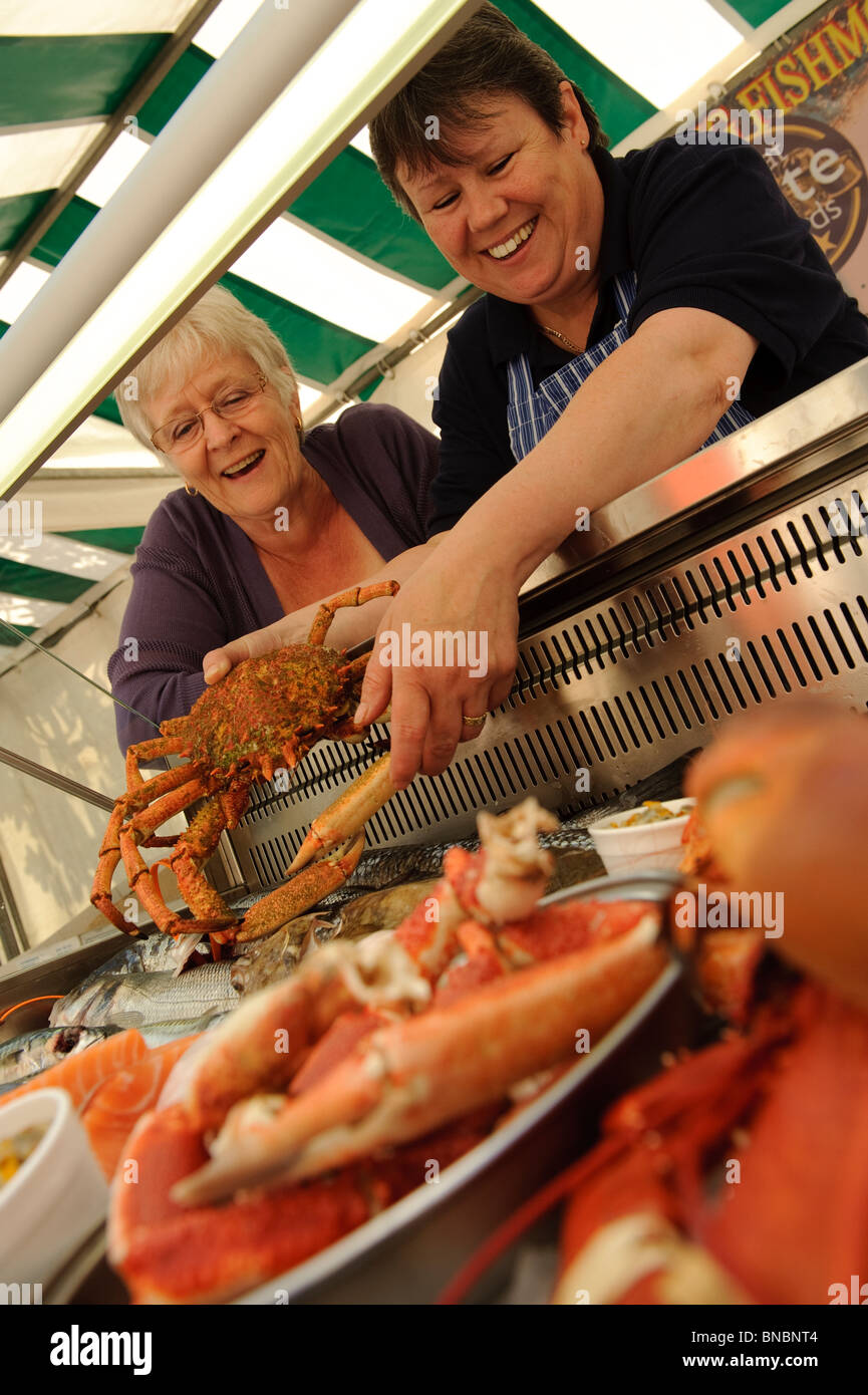 Eine Frau kauft frische Meeresfrüchte am Bauernmarkt Aberystwyth, Wales UK Stockfoto