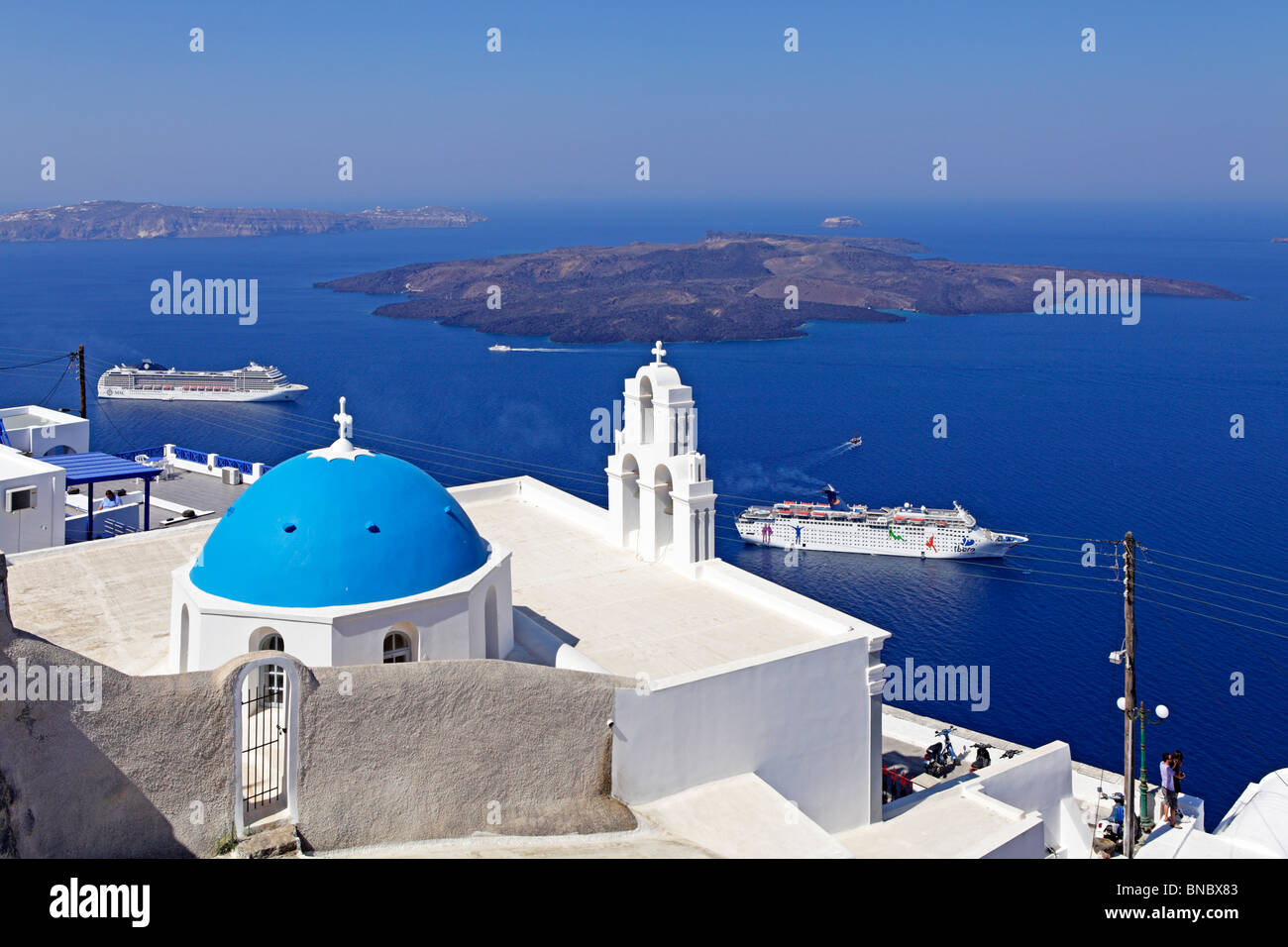die weiße Kirche mit einer blauen Kuppel vor dem blauen Ägäischen Meer, Fira, Santorin, Cyclades, Ägäische Inseln, Griechenland Stockfoto