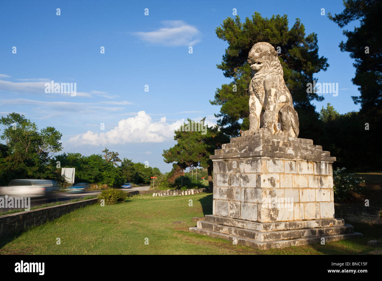 Der hellenistischen Löwe von Amphipolis mit Autos Rauschen vorbei auf die moderne Strasse neben ihm. Stockfoto