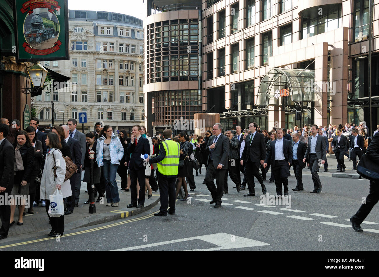 Menge von Menschen, die aus einem Gebäude in der Nähe von Liverpool Street Station London England UK evakuiert Stockfoto