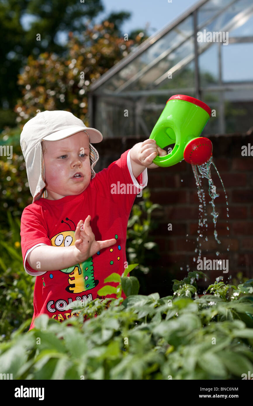 Junge, die Bewässerung des Gartens Stockfoto