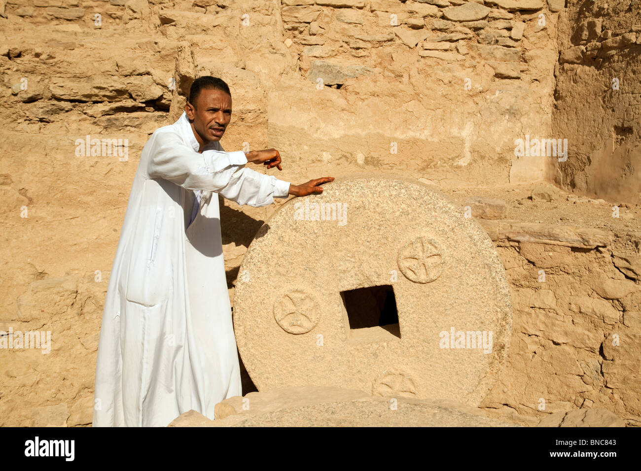 Tourguide zeigt einen alten Mühlstein, der koptischen Kloster von St. Simeon, in der Nähe von Assuan, Ägypten, Afrika Stockfoto