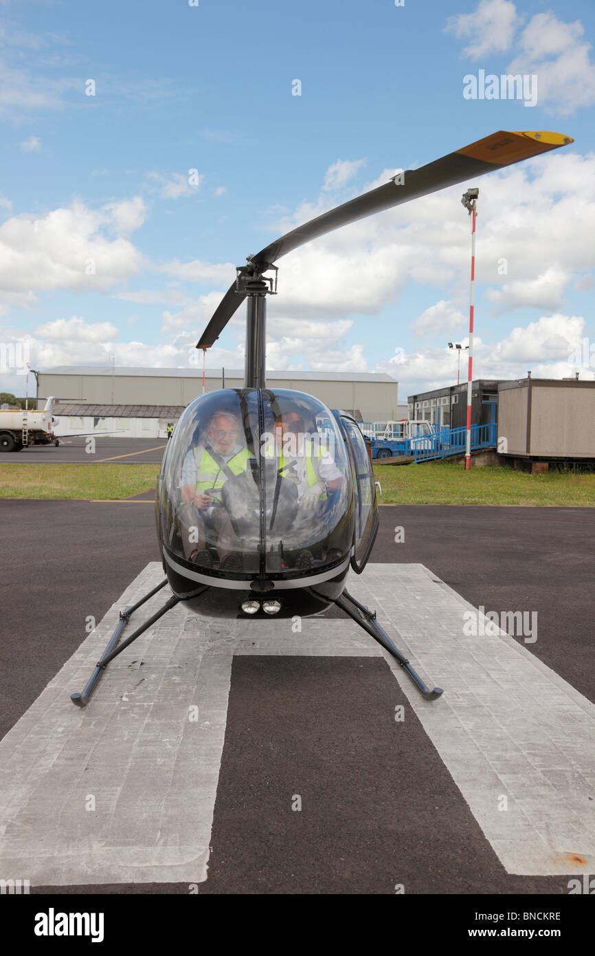 Hubschrauber mit Pilot Unterweisung seines Schülers auf Carlisle Flughafen in Cumbria, England, Vereinigtes Königreich auf das Heli-Pad an sitzt. Stockfoto