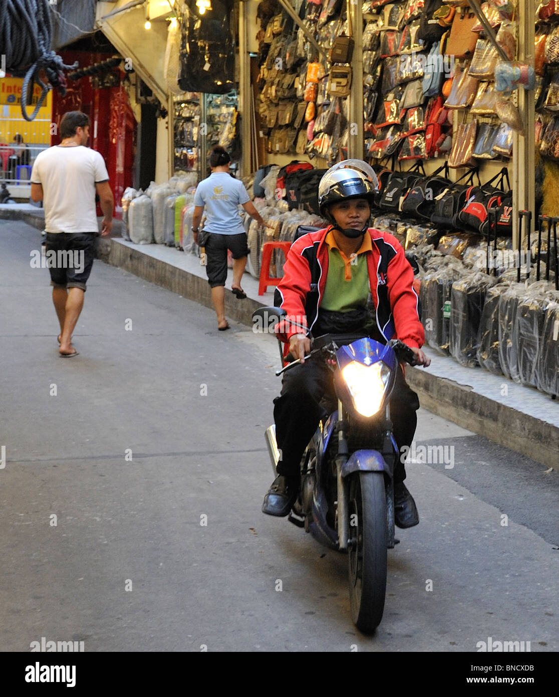 Motorradfahrer auf der Durchreise des engen Marktes Stände in Patpong Nachtmarkt, Bangkok Stockfoto Motorradfahrer auf der Durchreise des engen Marktes Stände in Patpong Nachtmarkt, Bangkok Stockfoto