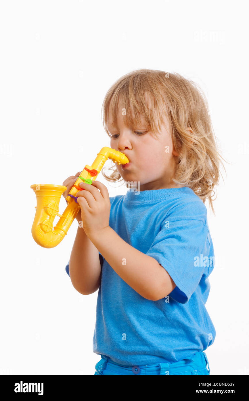 Junge mit langen blonden Haaren spielen mit Spielzeug-Saxophon Stockfoto