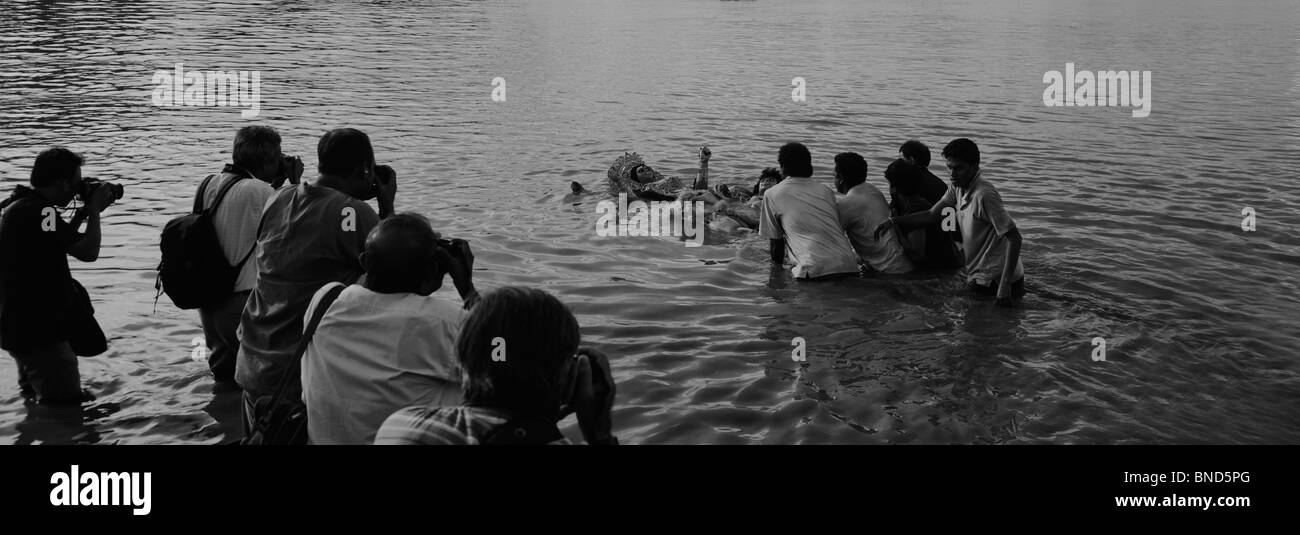 Touristen fotografieren der feierlichen Eintauchen der Göttin Durga im Fluss Hooghly River, Kolkata, Westbengalen, Indien Stockfoto