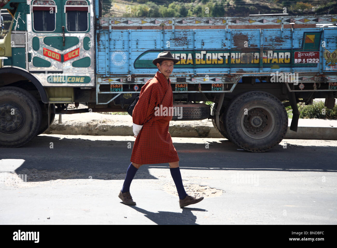 Ein Fußgänger Spaziergänge vorbei an einem LKW auf der Straße in Paro, Bhutan. Stockfoto