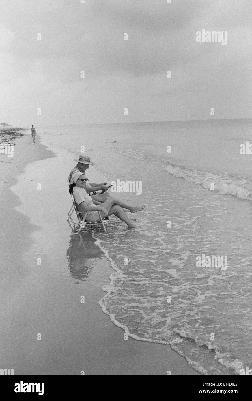 Älteres Paar am Strand sitzen Stockfoto