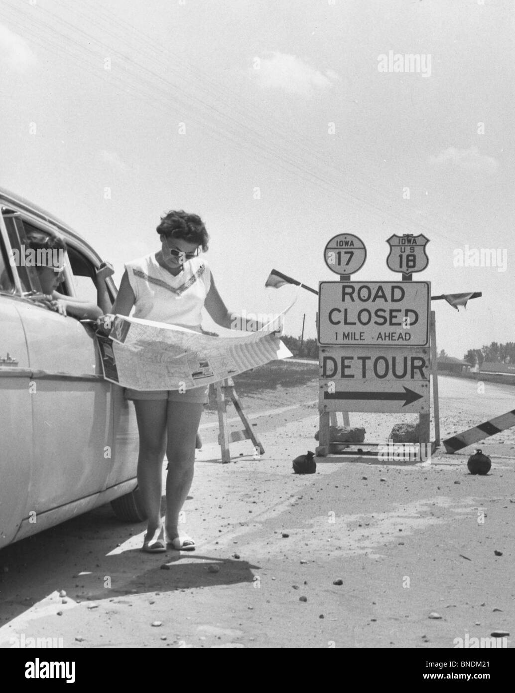 Junge Frau Kartenlesen vor ein Straßenschild geschlossen Stockfoto