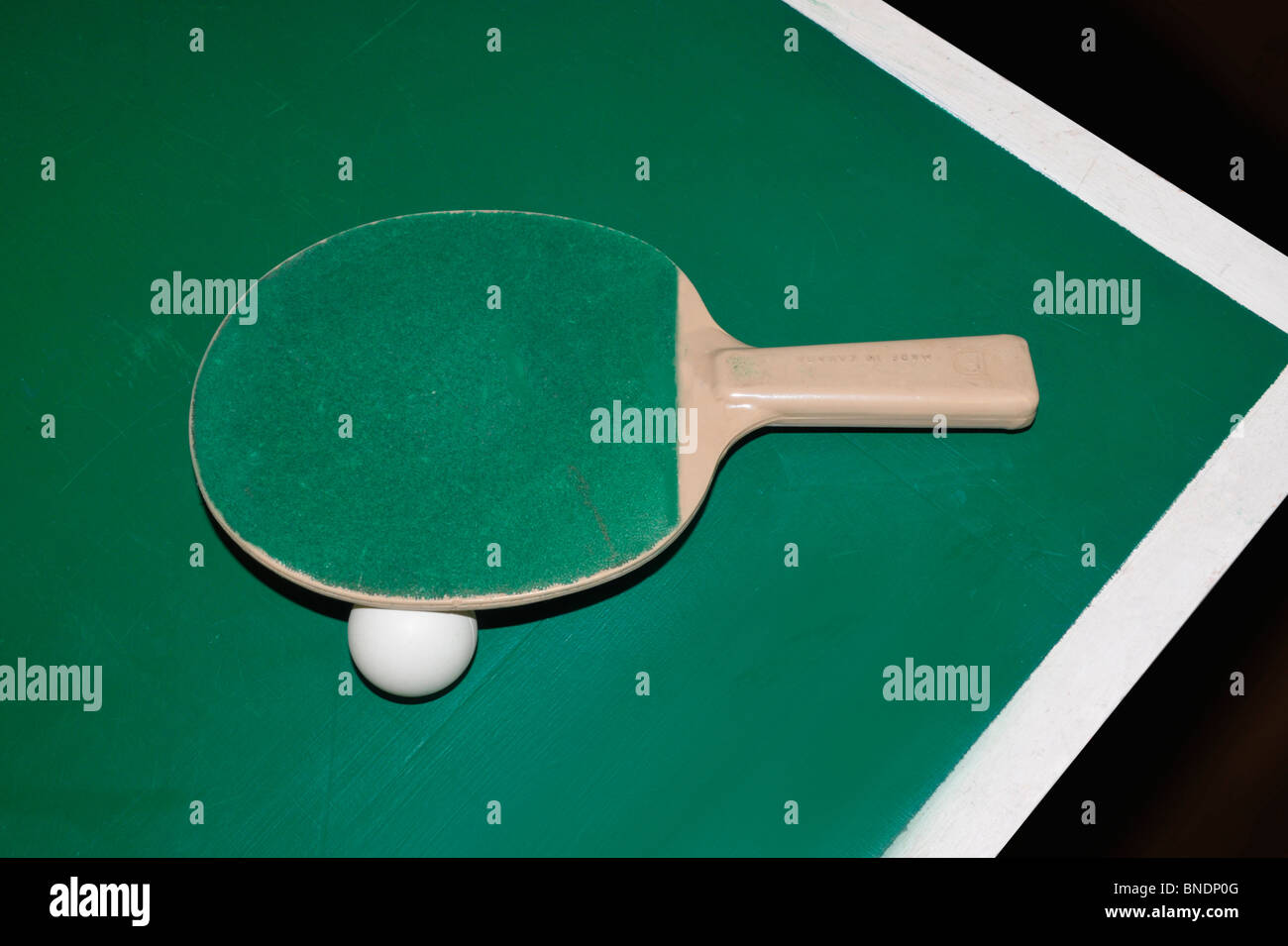 Ein Ping-Pong-Schläger und Ball sitzen am Rande des Tischtennis. Stockfoto