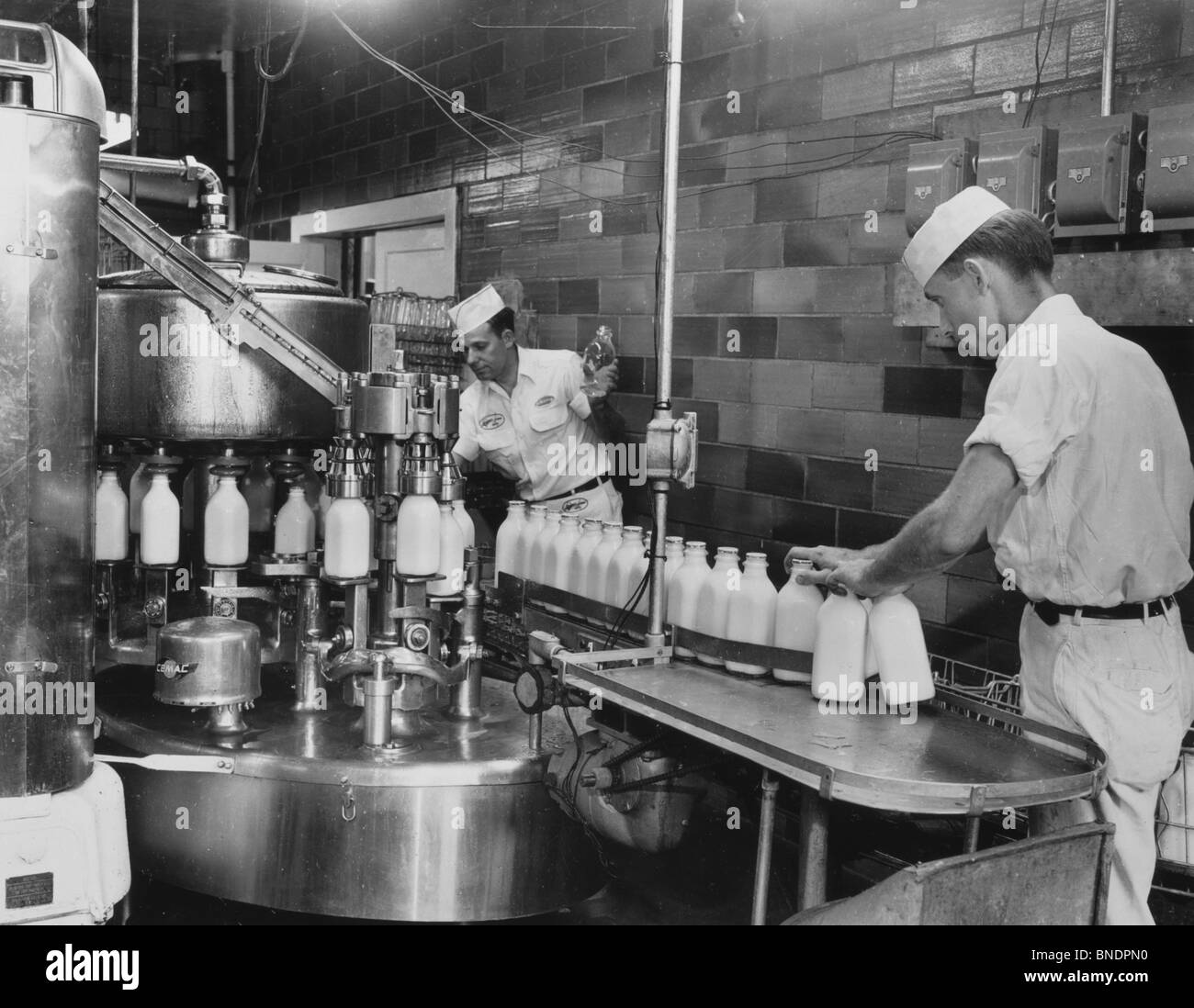 Seitenansicht zweier Mitte Erwachsene Männer in einer Abfüllanlage, 1945 Stockfoto
