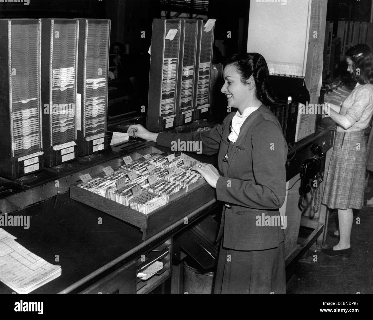 Seitenansicht zweier junger Frauen, die Vermittlung von Karteikarten, 1945 Stockfoto