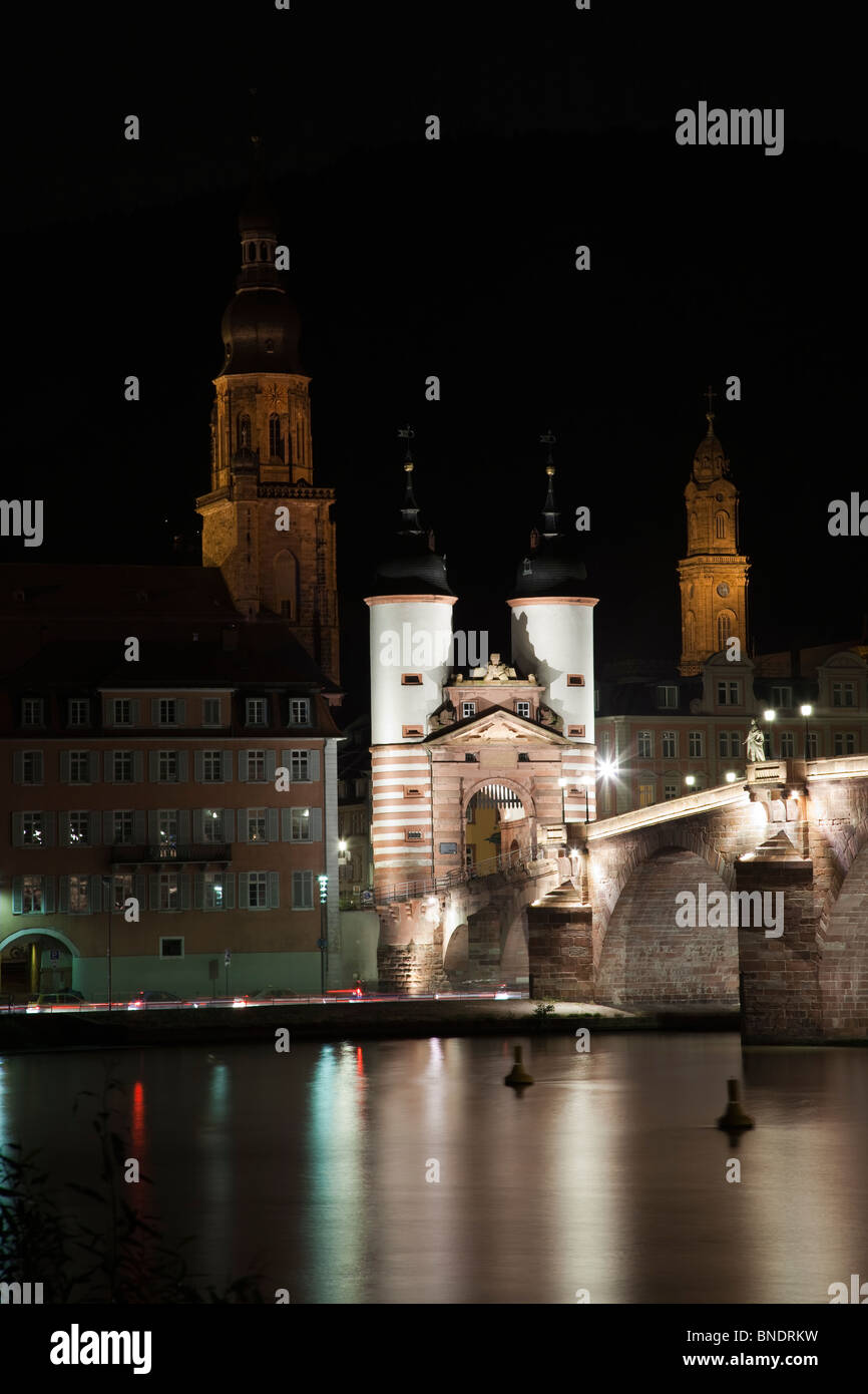 Historische alte Heidelberger Brücke schöne Nacht Lichter, Reflexionen in weich fließender Neckar Wasser, Kirchtürme schwarzen Hintergrund Bayern Deutschland Stockfoto