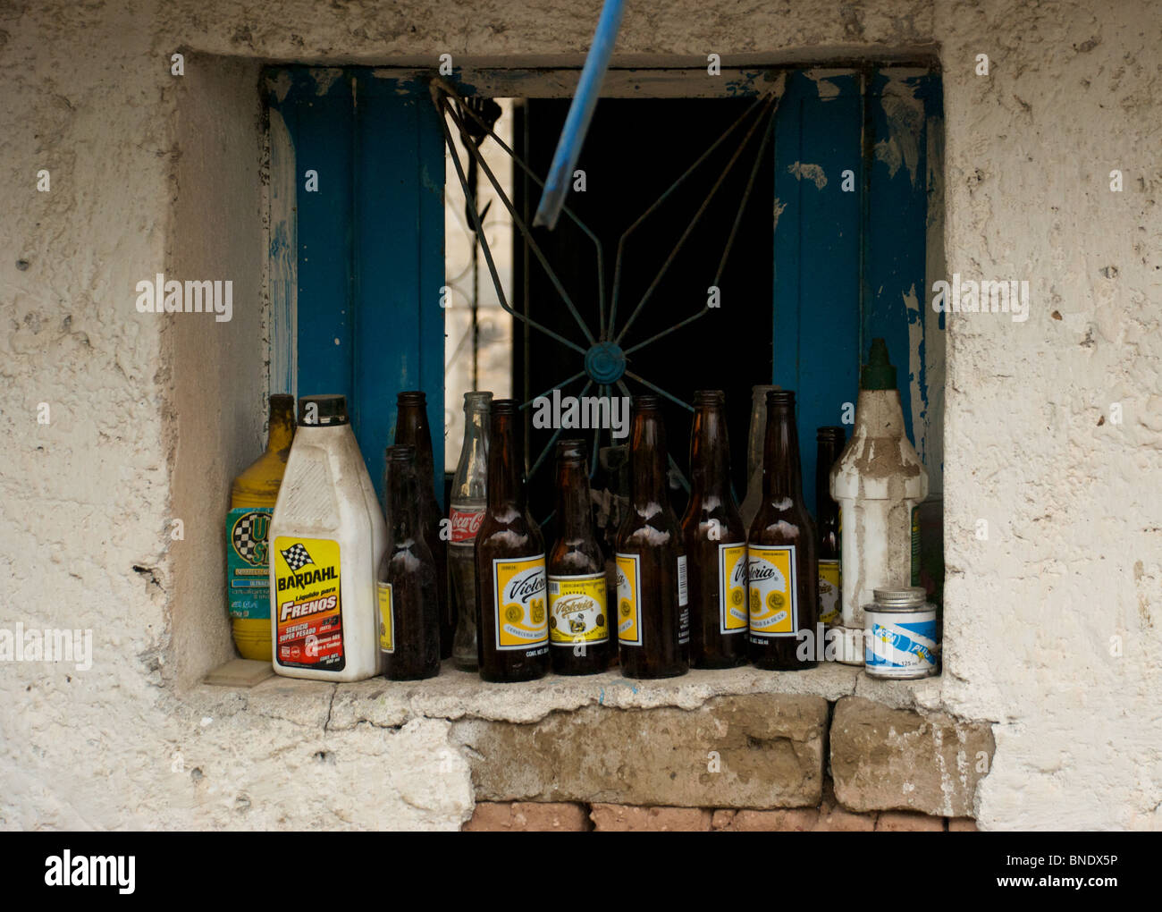 Fensterbank im ländlichen Mexiko dient als ein Ort, um eine Auswahl an Flaschen vor dem recycling und Wiederverwendung zu speichern. Stockfoto