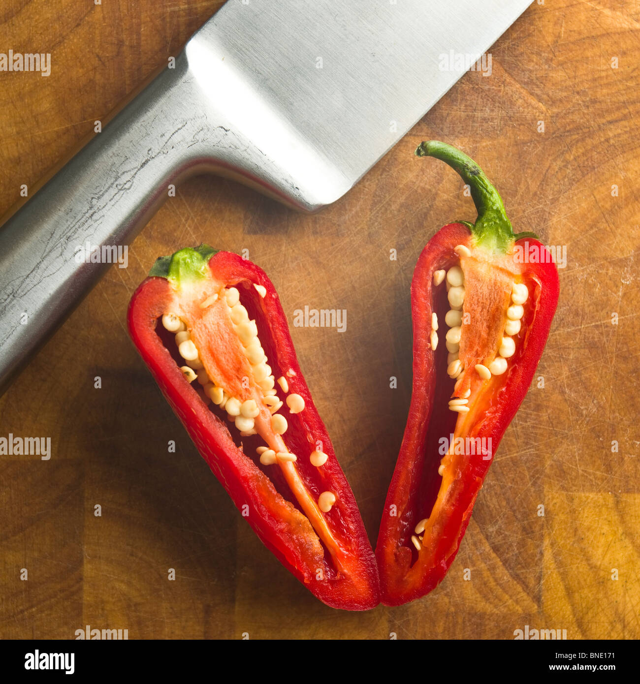 Chill in Scheiben geschnittenen Paprika mit Messer auf Bambus Hackstock Stockfoto