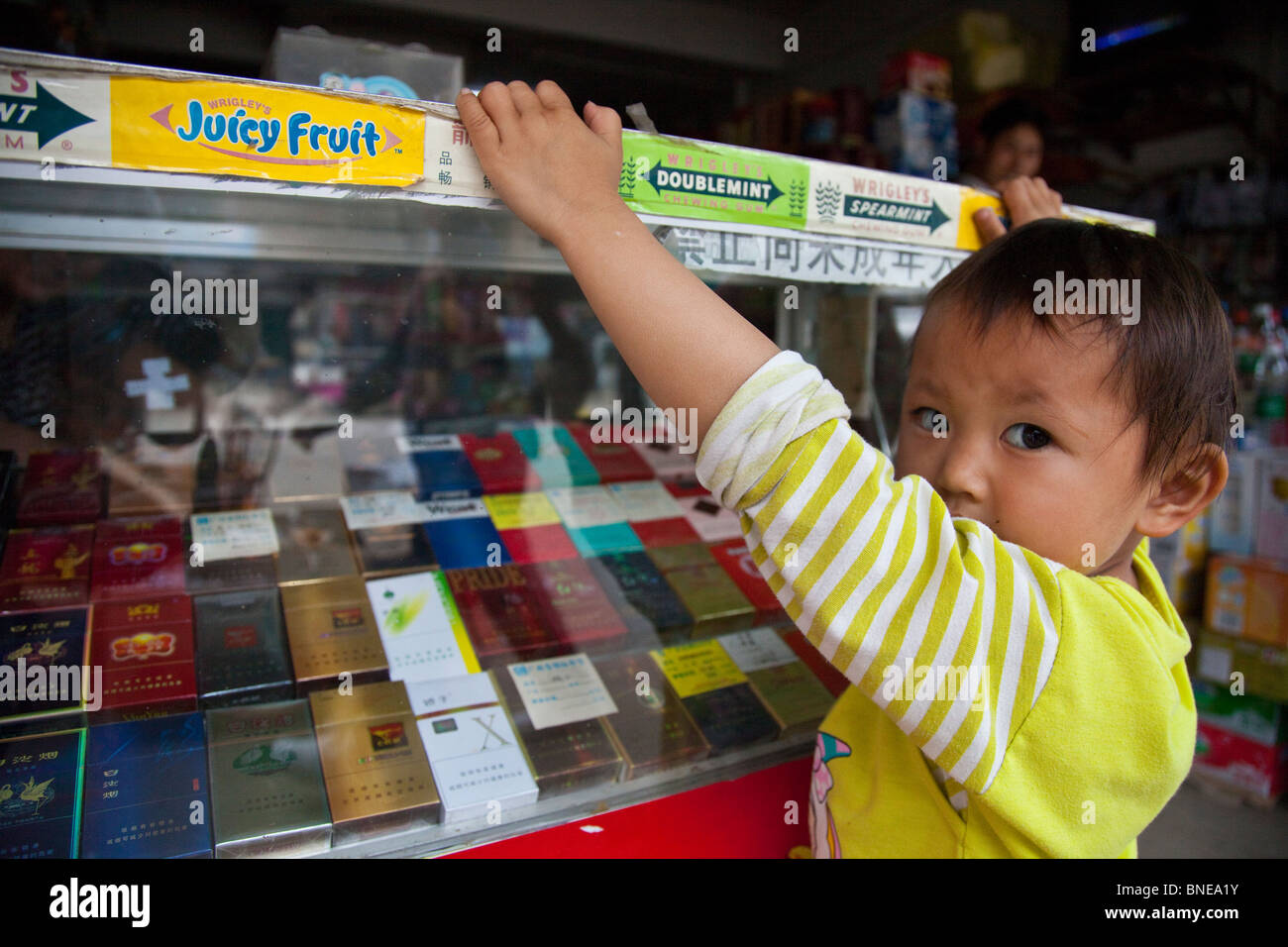 Kleines Mädchen an der Theke Zigarette von ihrer Familie Convenicence speichern in Xingping, Provinz Guangxi, China Stockfoto