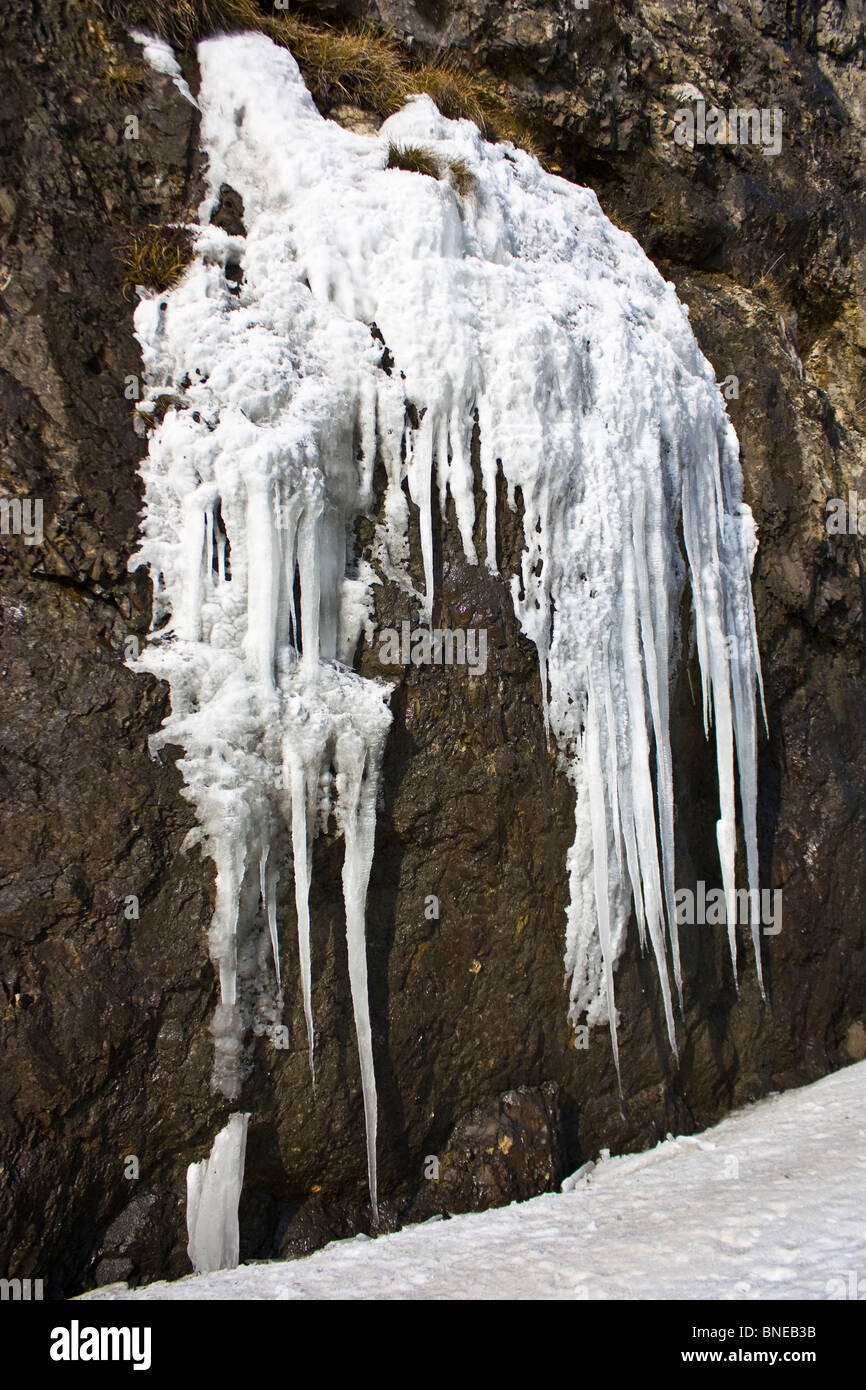 Kleinen gefrorenen Wasserfall auf braunen Felsen im winter Stockfoto