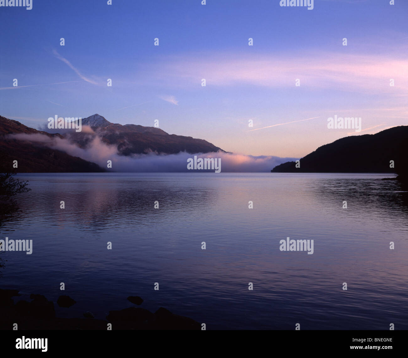 Am frühen Morgennebel fangen Sonnenlicht auf Loch Lomond, Schottland, UK Stockfoto