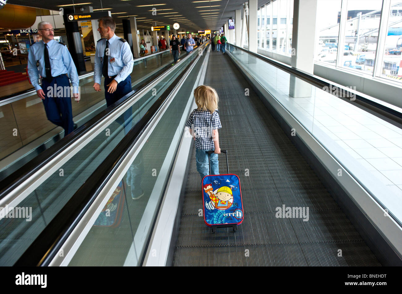 Drei Jahre alten Jungen auf seinem Weg zur Abflughalle am Flughafen Schiphol in den Niederlanden, Europa Stockfoto