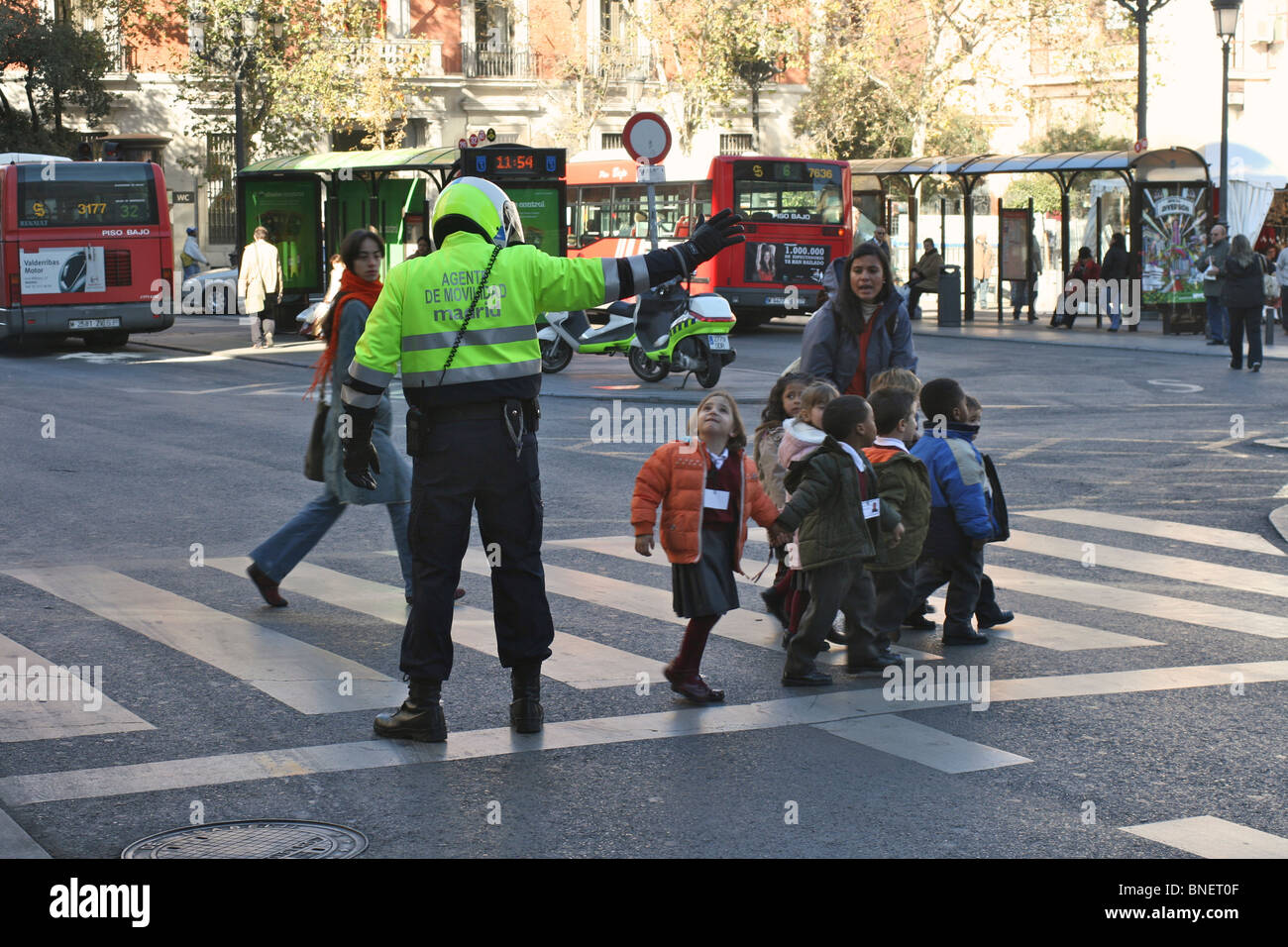 Ein "Agent de Movilidad" (Mobilität Polizist) unterstützt eine Gruppe von 8 Kindern, Calle de Atocha in Madrid zu überqueren Stockfoto
