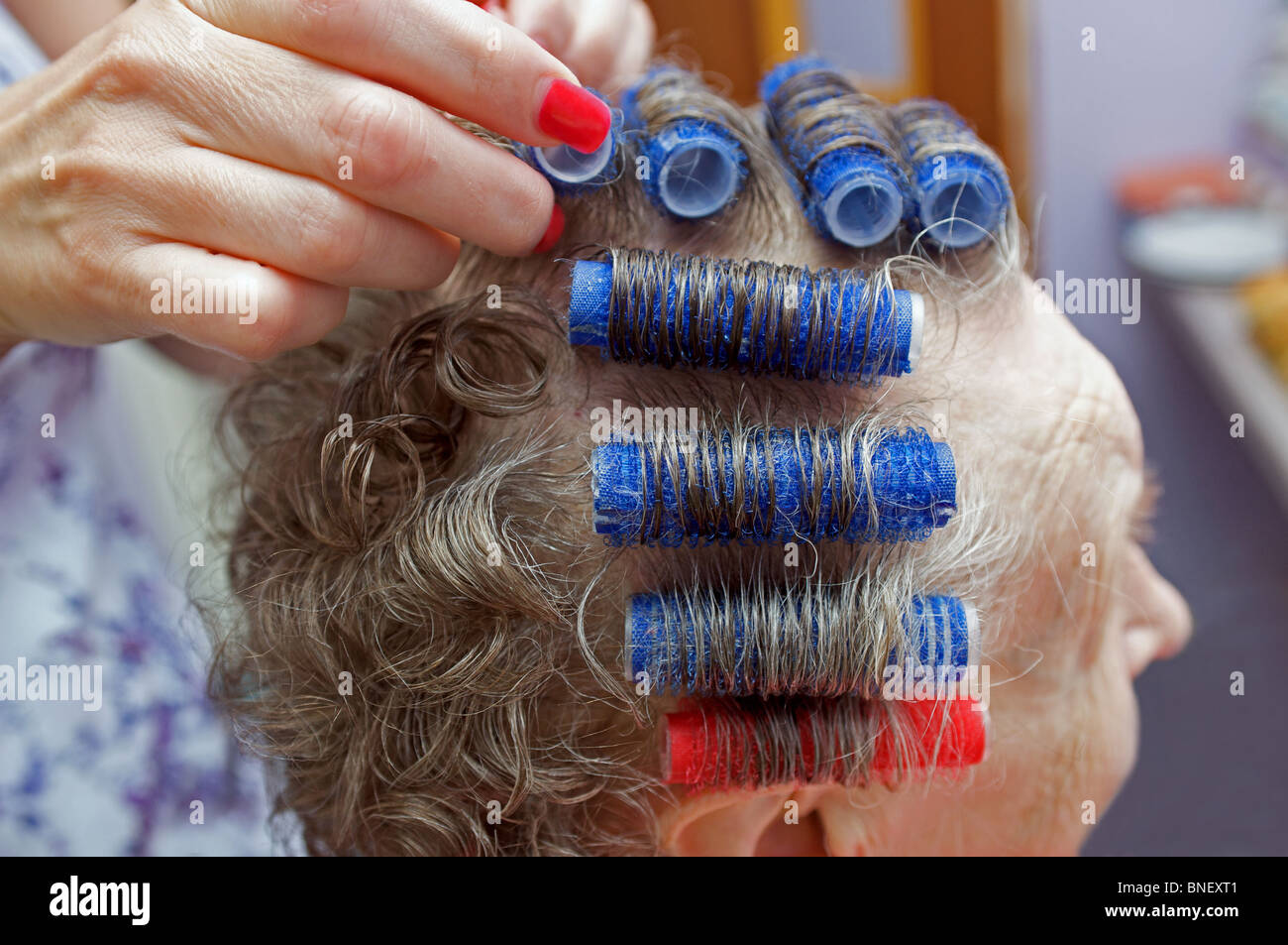 Alter Rentner mit Haaren ins Rollen in einem Pflegeheim, Ipswich, Suffolk, UK. Stockfoto