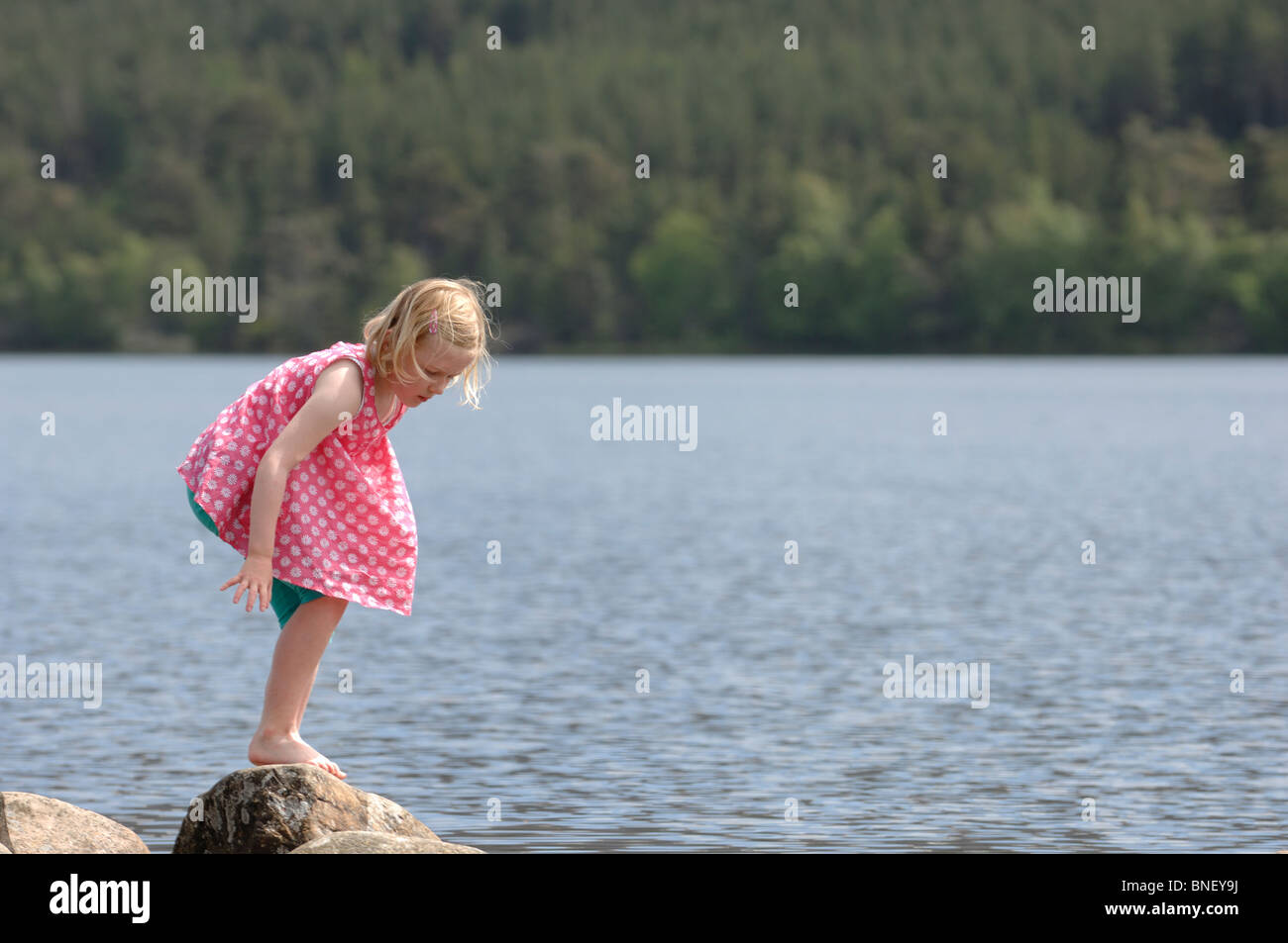 Eine junge Blondine in ein rosa Top und türkisen Leggings paddeln am Ufer des Loch Morlich in der Nähe von Aviemore Inverness-shire Stockfoto