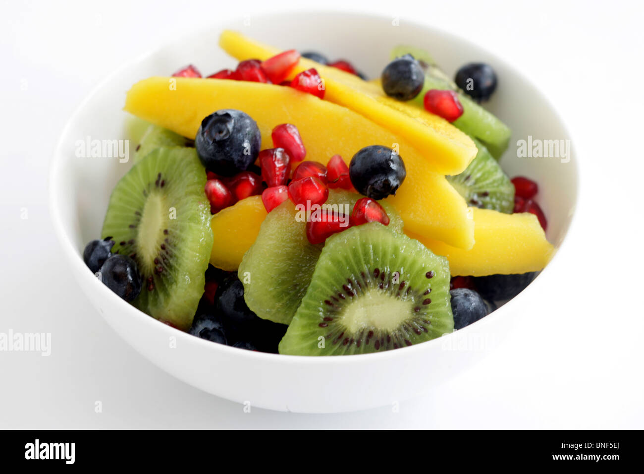 Frische, gesunde Tropischer Obstsalat mit Mango Kiwi und Granatapfel Samen serviert in einer Schüssel mit Keine Personen Stockfoto