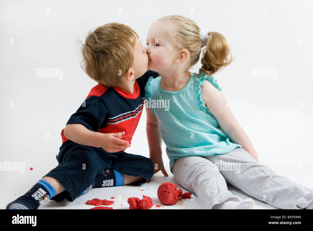 Porträt von zwei Kleinkinder jungen und Mädchen küssen, erste Liebe, beste Freunde, Isolated on White Stockfoto