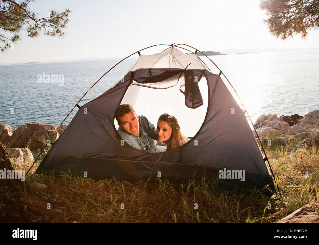 Paar im Zelt auf dem Seeweg liegend Stockfoto