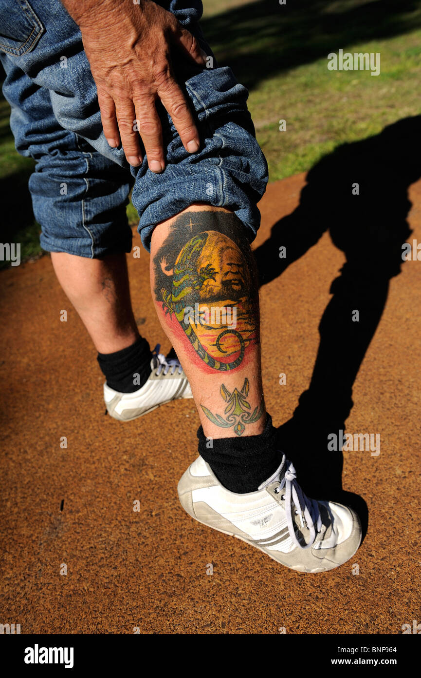 Tattoo mit Australian Aboriginal Flagge; Aborigines Tiermotive; und Portrait von Aborigines Mann. Perth, Western Australia, Australia Stockfoto