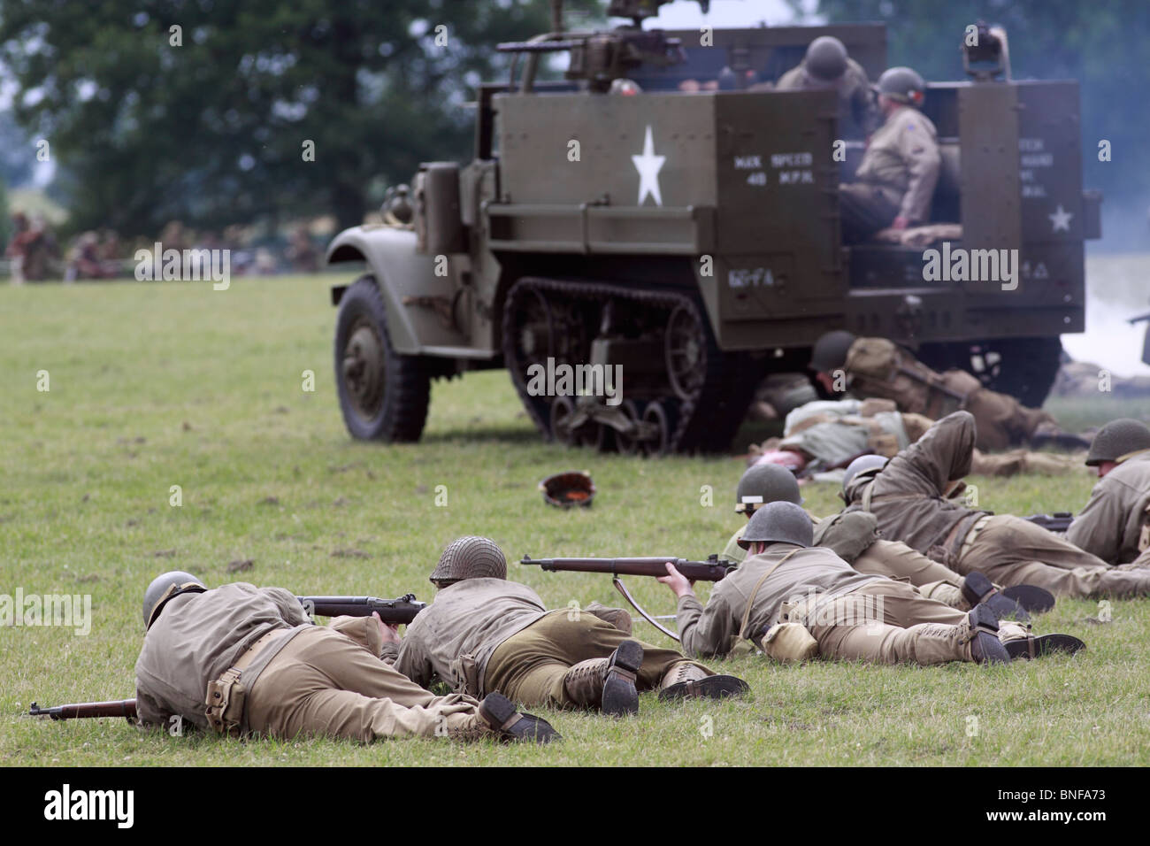 WWII Reenactment. Vereinigten Staaten Infanterie auf den Angriff von einem Mannschaftswagen uns M3A1 Halbkettenfahrzeug. Die MSA1 kennzeichnete eine erhöhte, gepanzerten "Kanzel Mount" für das Kaliber.50 und.30-Kaliber (7,62 mm) Maschine Gewehren von Halterungen an den Seiten des Fahrgastraums genutzt werden. Der Körper war rundum mit einem verstellbaren gepanzerte Shutter für den Motor kühler und einer kugelsicheren Windschutzscheibe gepanzert. Festival der Geschichte 2010, Kelmarsh Hall, Northamptonshire. Re-Anactors erleben Sie britische Geschichte von den Römern bis zum zweiten Weltkrieg Stockfoto