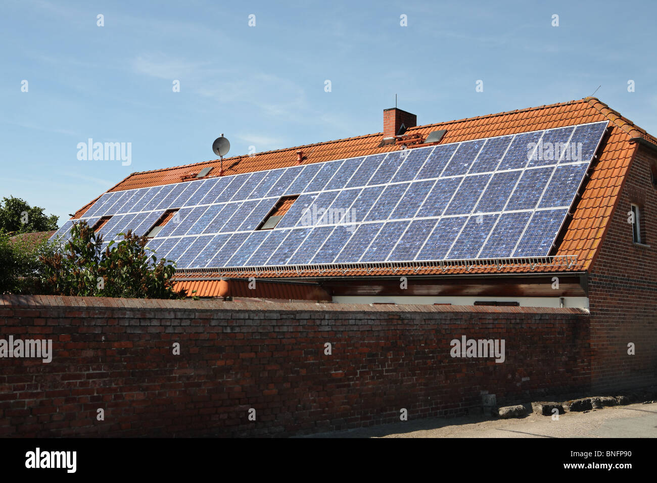Photovoltaik und Sonnenkollektoren auf dem Dach eines Bauernhauses im Dorf Bälow in Deutschland montiert. Stockfoto