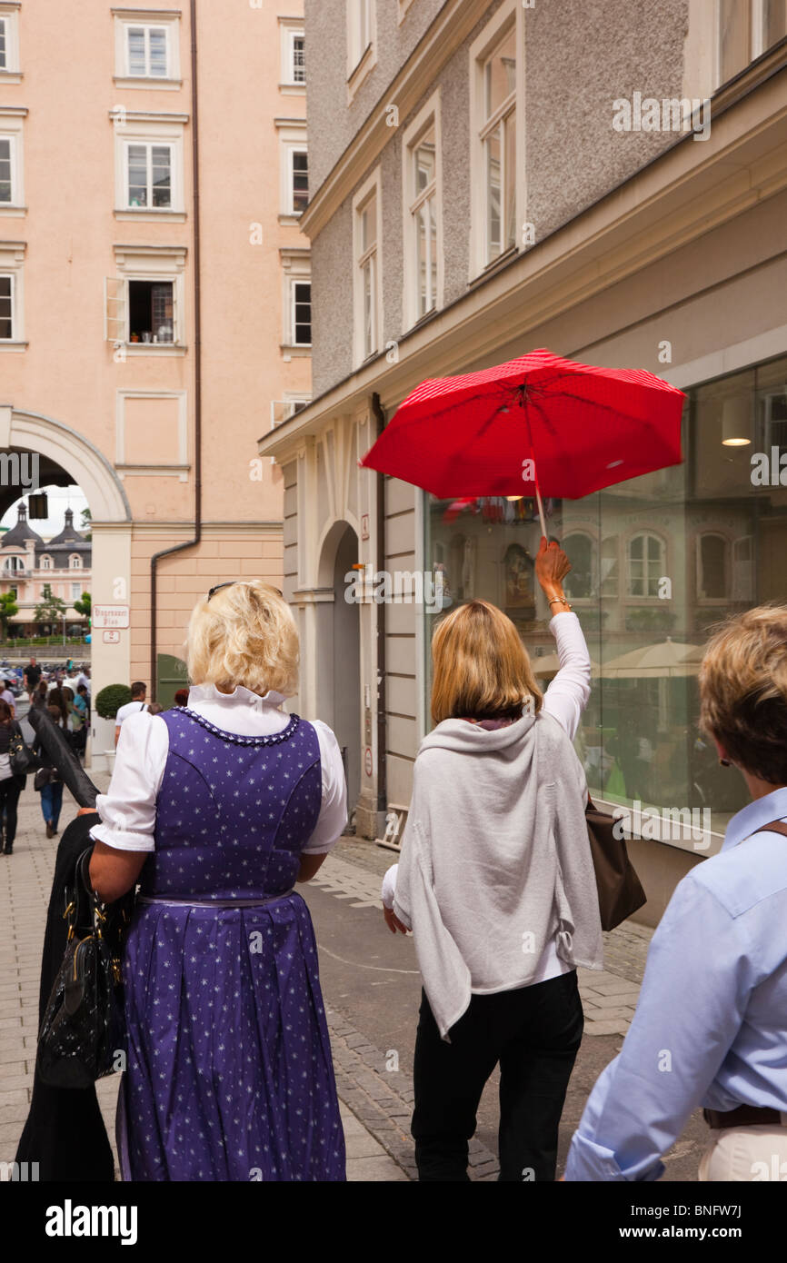 Salzburg, Österreich, Europa. Frau Reiseführer hält einen roten Regenschirm  hoch oben in der Altstadt Stockfotografie - Alamy