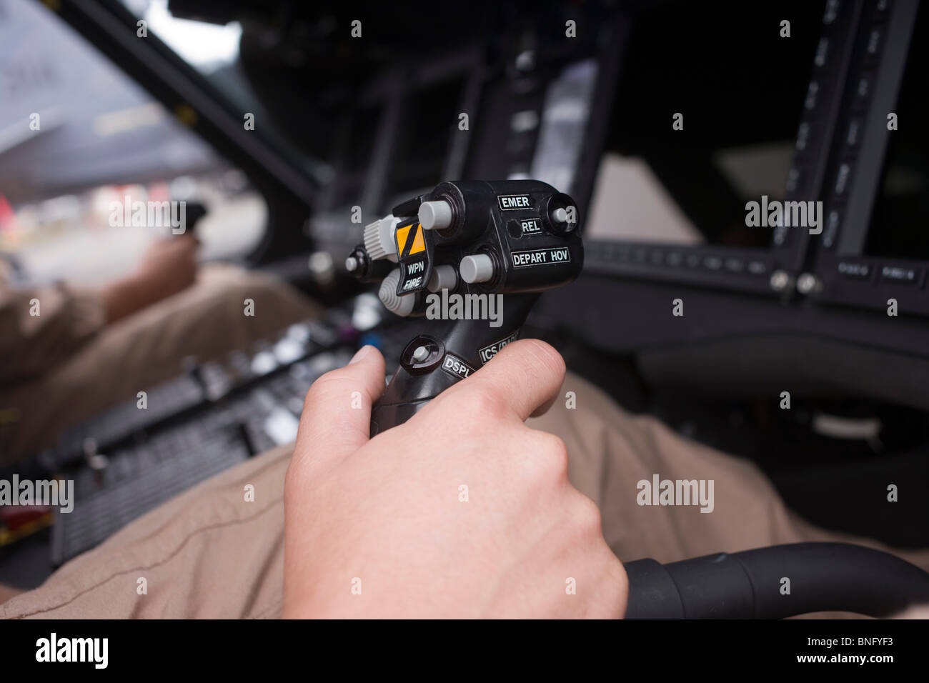 U.S. Navy Pilot begreift zyklische Stock in das Cockpit eines Helikopters Sikorsky MH-60R auf der Farnborough Airshow. Stockfoto